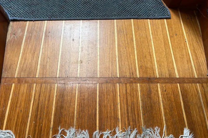 Slide: The Image of Teak wood flooring on a 1998 Sabre 362 boat, with a textured mat. - 18