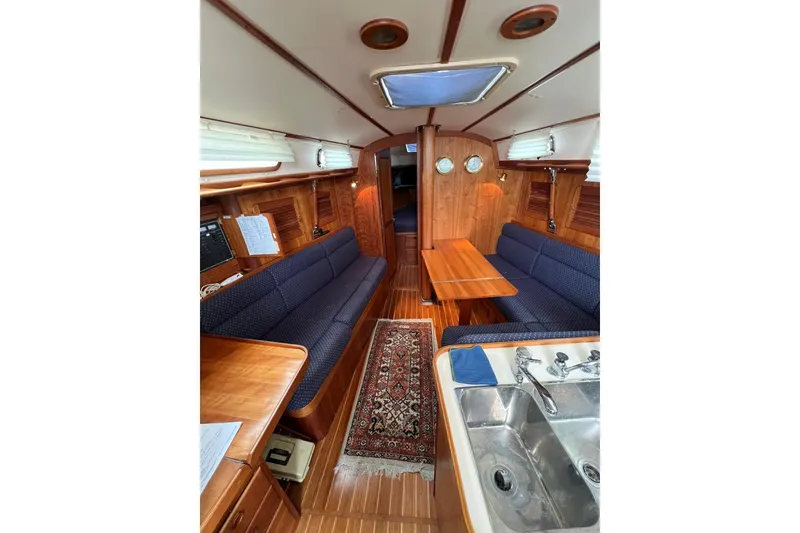 Slide: The Image of Interior of 1998 Sabre 362 sailboat with wooden finish, blue seating, and compact kitchen area. - 19