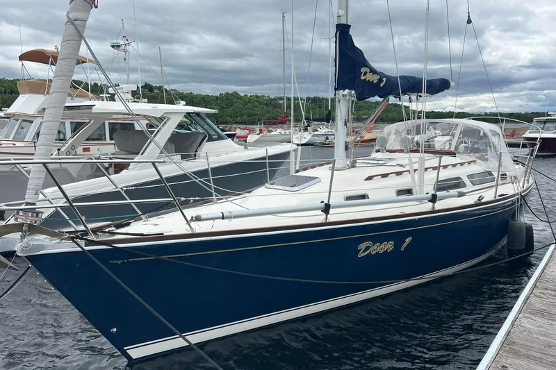 Slide: The Image of 1998 Sabre 362 sailboat docked in marina, featuring blue hull and white deck. - 2