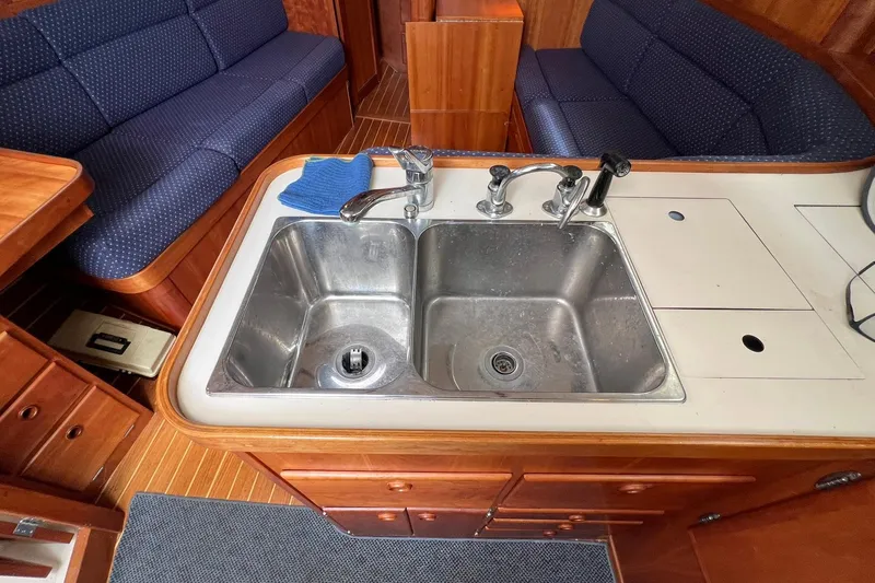 Slide: The Image of Galley sink in 1998 Sabre 362 yacht with wooden cabinetry and blue upholstered seating. - 25