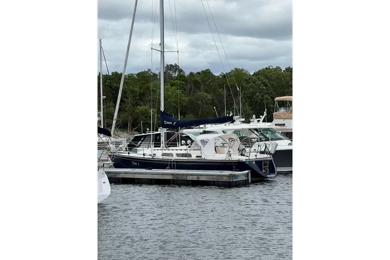 Slide: The Image of 1998 Sabre 362 sailboat docked at marina, surrounded by lush greenery and calm waters. - 3