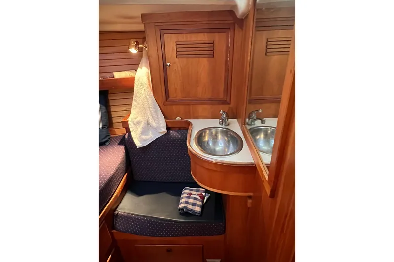 Slide: The Image of Cozy 1998 Sabre 362 yacht interior with wooden cabinetry and compact sink area. - 33