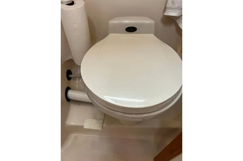 Slide: The Image of 1998 Sabre 362 marine toilet with paper holder in compact bathroom setting. - 35
