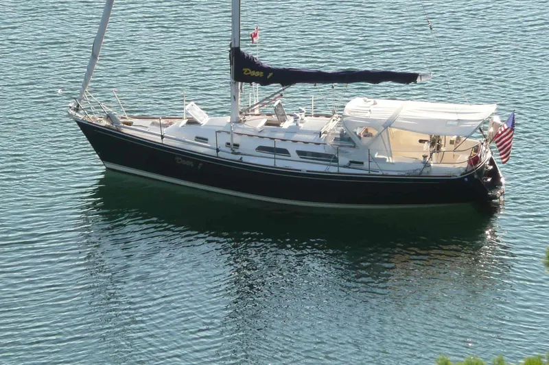 Slide: The Image of Sailboat Sabre 362, 1999 model, anchored on calm water with flags displayed. - 6