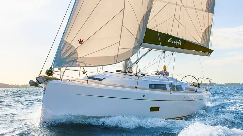 The Image of Sailboat on the water with white sails and a blue sky. - 0