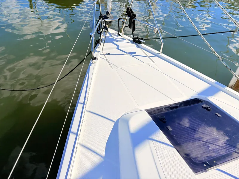 Slide: The Image of The deck of a white sailboat on calm water. - 19
