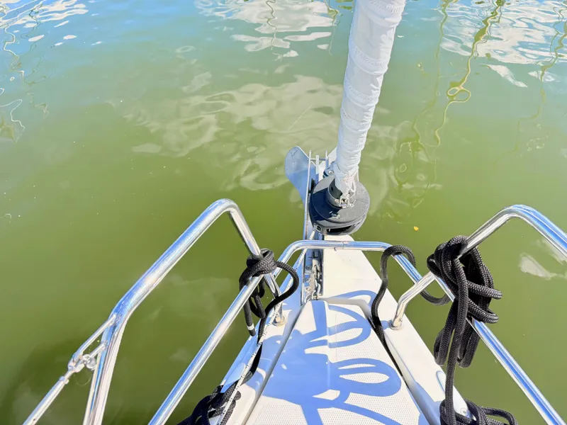 Slide: The Image of Bow of a sailboat with stainless steel railing and anchor over greenish water. - 20