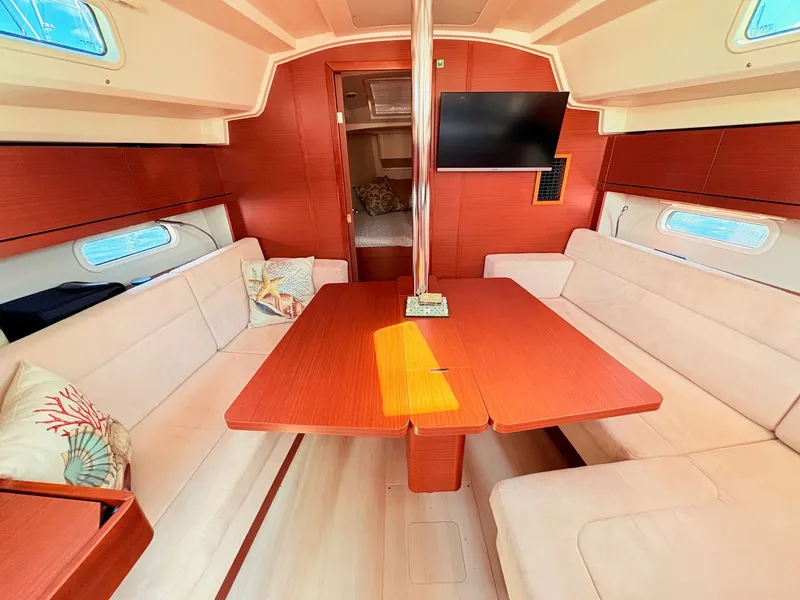 Slide: The Image of Interior of a Hanse 348 yacht with a wooden table and beige sofas. - 29
