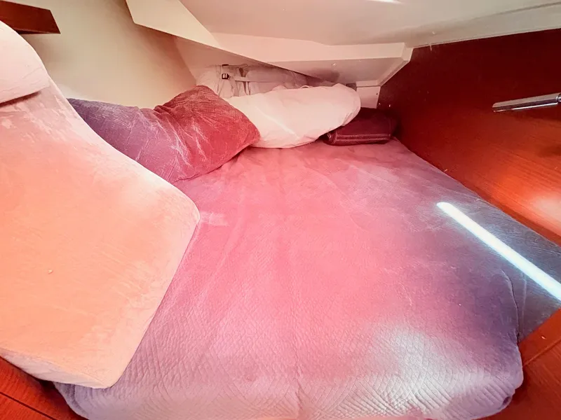 Slide: The Image of A cozy bed in a boat cabin with pink and white pillows. - 31