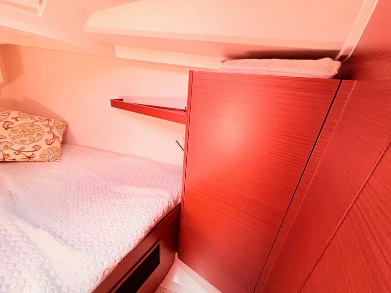 Slide: The Image of Interior of a Hanse 348 yacht with a bed and wooden cabinet. - 32