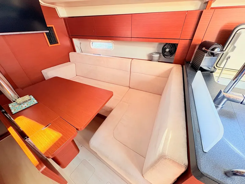 Slide: The Image of Interior of a Hanse 348 yacht with a cozy seating area and table. - 38