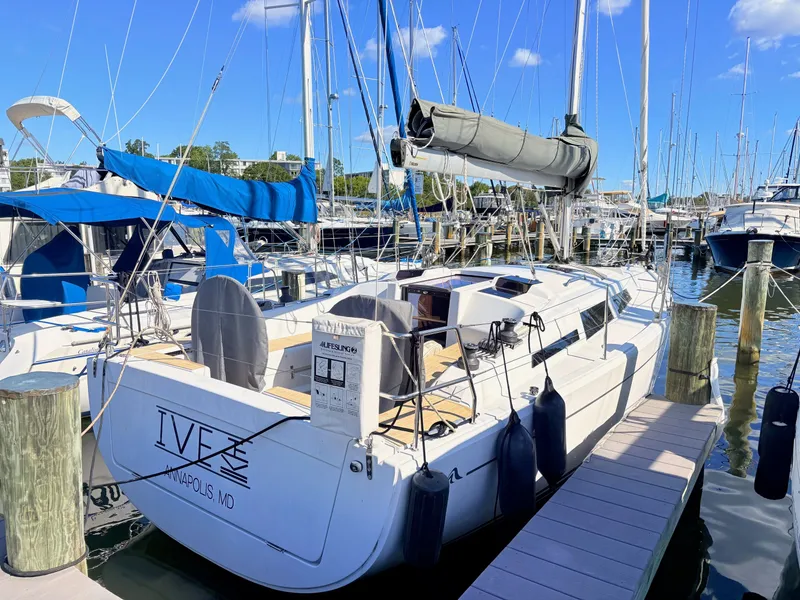 Slide: The Image of Sailboat docked in a marina with blue skies and other boats in the background. - 4