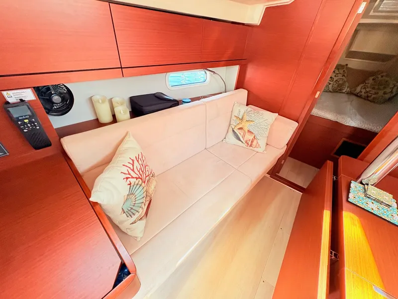 Slide: The Image of Interior of a Hanse 348 with a cream sofa and nautical-themed pillows. - 40
