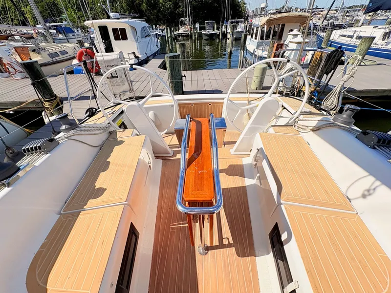Slide: The Image of The cockpit of a Hanse 348 yacht with dual steering wheels and wooden flooring. - 46