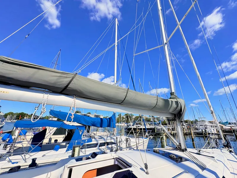 Slide: The Image of A modern sailboat in a marina with a blue sky and other boats in the background. - 47