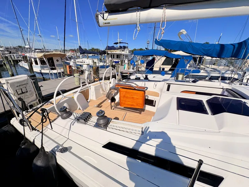 Slide: The Image of The deck of a Hanse 348 yacht in a marina, featuring steering wheels and wooden flooring. - 49