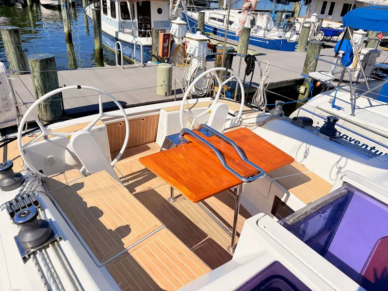 Slide: The Image of The deck of a Hanse 348 yacht with dual steering wheels and a wooden table. - 7