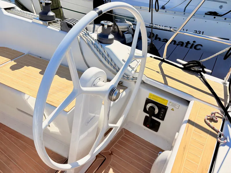 Slide: The Image of The image shows the steering wheel of a Hanse 348 yacht with a wooden deck. - 8