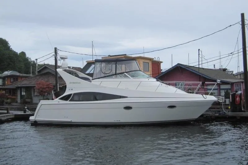 Slide: The Image of 2006 Carver 36 Mariner yacht docked near colorful waterfront buildings. - 1