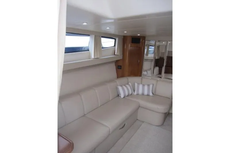 Slide: The Image of Interior of 2006 Carver 36 Mariner yacht with beige seating and striped pillows. - 11