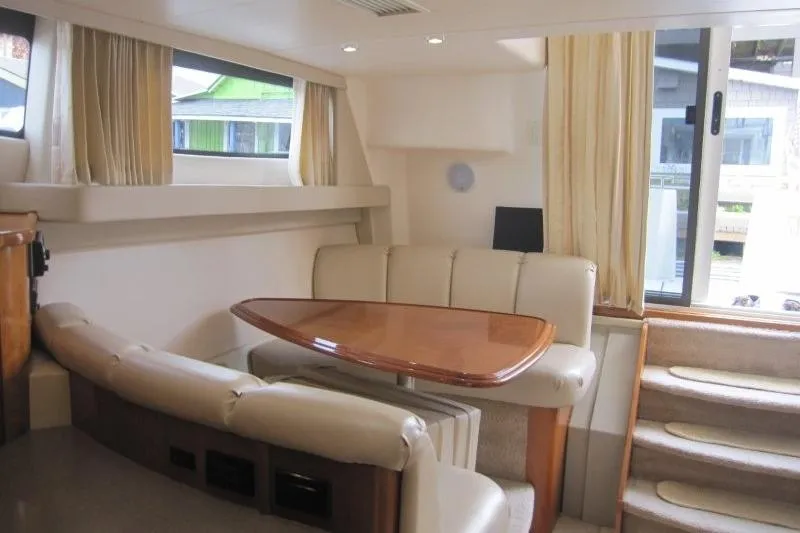 Slide: The Image of Interior of 2006 Carver 36 Mariner yacht with elegant seating and wooden table. - 16