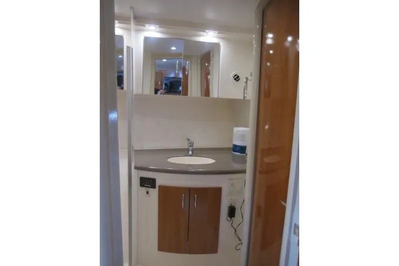 Slide: The Image of 2006 Carver 36 Mariner bathroom with modern sink, mirror, and wooden cabinetry. - 18