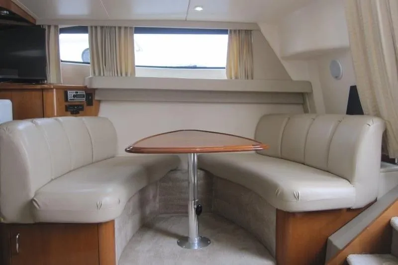 Slide: The Image of Interior of 2006 Carver 36 Mariner yacht with beige seating and wooden table. - 4