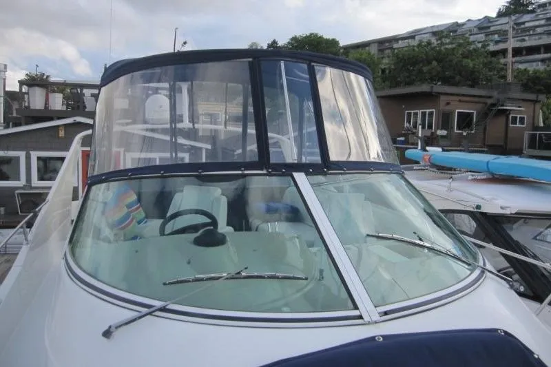 Slide: The Image of 2006 Carver 36 Mariner boat docked, featuring a clear windshield and blue canopy. - 31