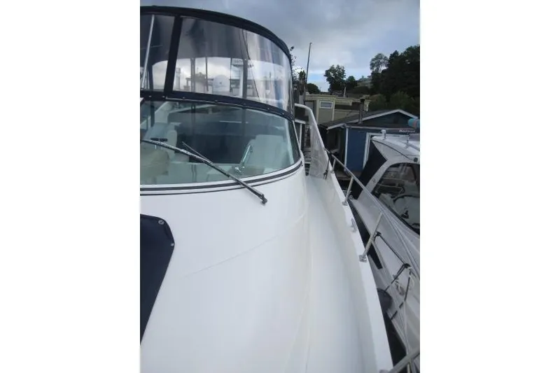 Slide: The Image of 2006 Carver 36 Mariner yacht docked, showcasing sleek white exterior and spacious deck. - 36