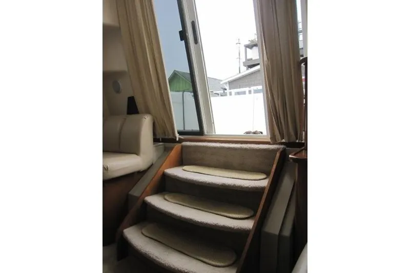 Slide: The Image of Interior stairs of a 2006 Carver 36 Mariner yacht with beige carpeting and window view. - 5