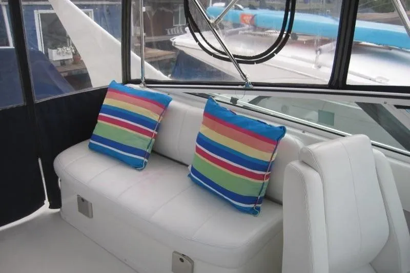 Slide: The Image of 2006 Carver 36 Mariner interior with white seating and colorful striped pillows. - 43