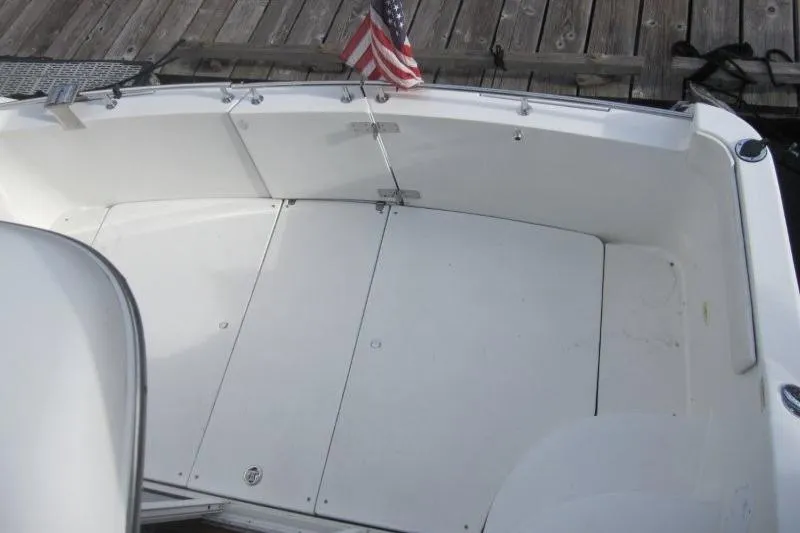 Slide: The Image of 2006 Carver 36 Mariner boat deck with American flag, docked at wooden pier. - 47