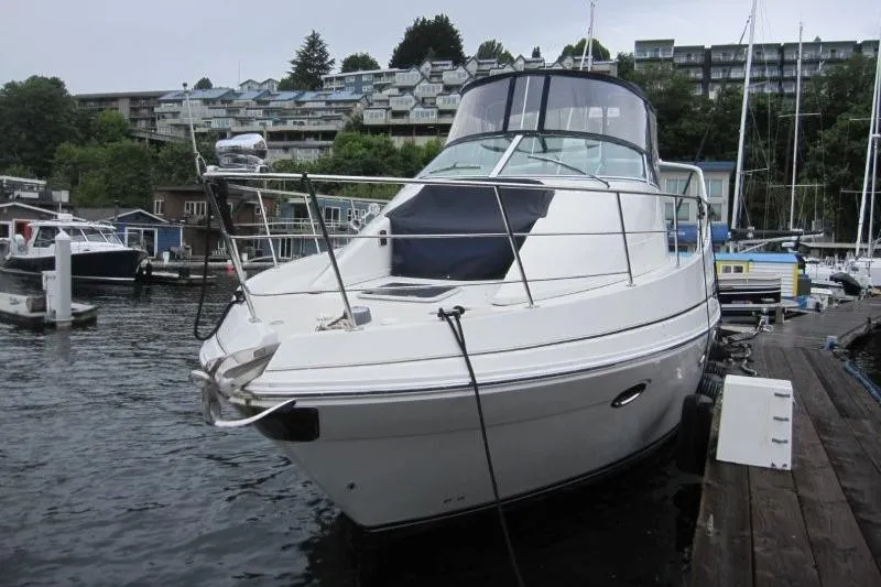 Slide: The Image of 2006 Carver 36 Mariner yacht docked at a marina with waterfront buildings. - 48