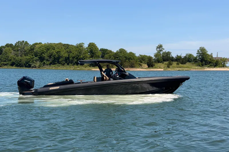 The Image of 2023 Skipper-BSK 42NC boat cruising on a serene lake with lush green shoreline. - 0