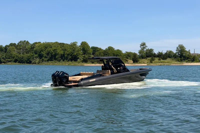 Slide: The Image of 2023 Skipper-BSK 42NC boat cruising on a serene lake with lush green shoreline. - 11