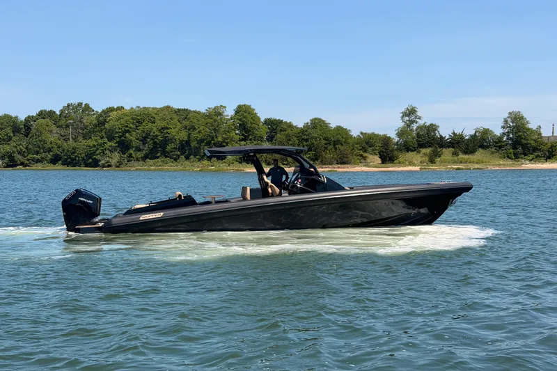 Slide: The Image of 2023 Skipper-BSK 42NC boat cruising on a serene lake with lush green shoreline. - 12