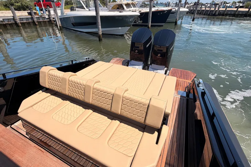 Slide: The Image of Luxury Skipper-BSK 42NC boat with beige seating and dual engines, docked in a marina. - 14