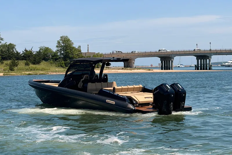 Slide: The Image of 2023 Skipper-BSK 42NC boat cruising near a bridge on a sunny day. - 2