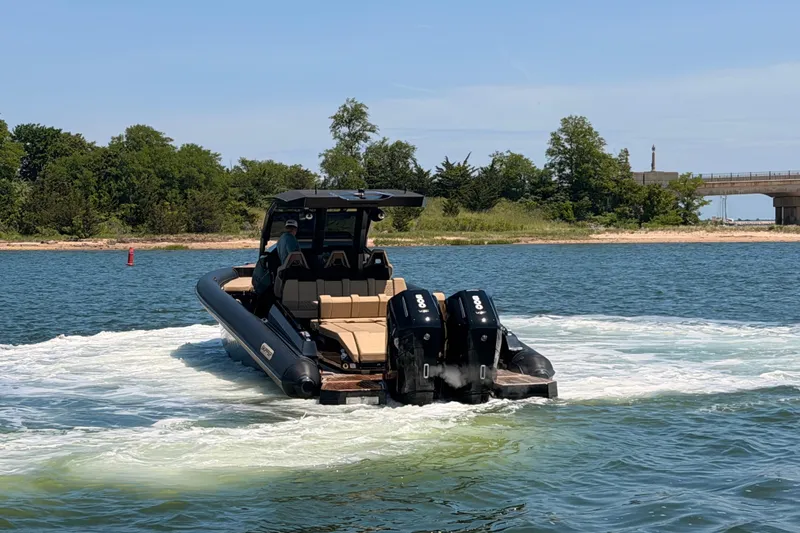 Slide: The Image of 2023 Skipper-BSK 42NC boat cruising on a scenic waterway with lush greenery. - 5