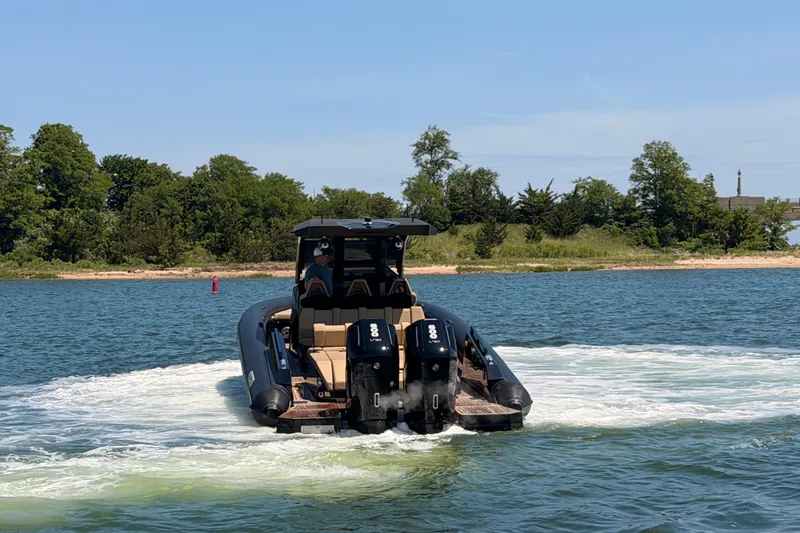 Slide: The Image of 2023 Skipper-BSK 42NC boat cruising on a lake with lush green shoreline. - 6