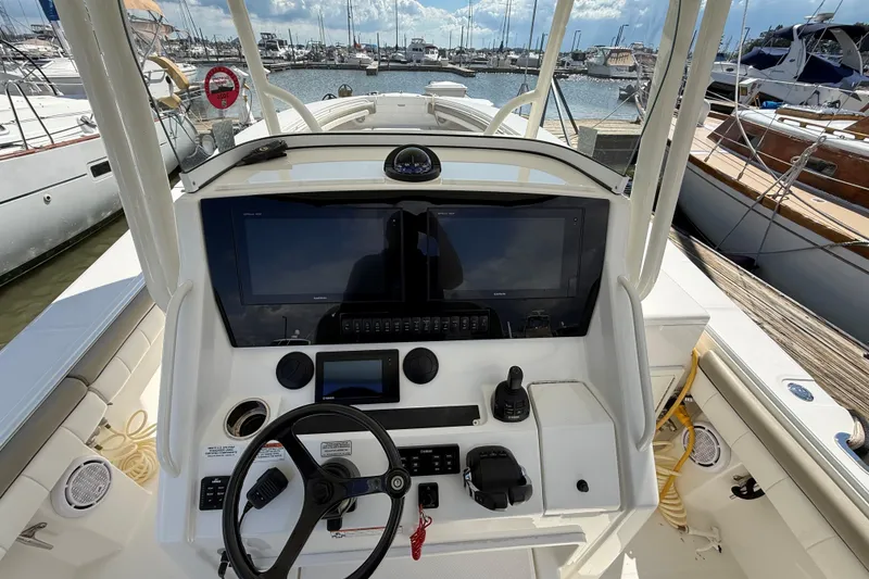 Slide: The Image of 2019 Regulator 34SS boat helm with advanced navigation controls at marina. - 12