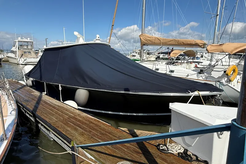 Slide: The Image of 2019 Regulator 34SS boat covered at marina dock under blue sky. - 23
