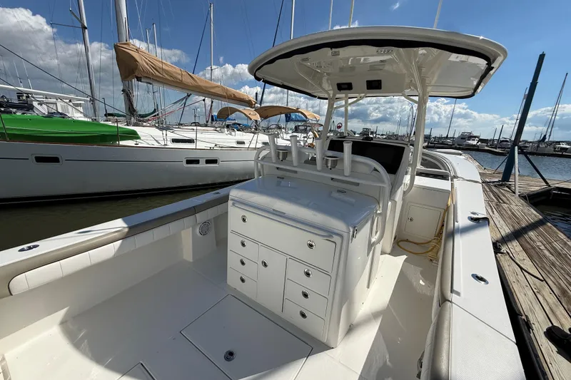 Slide: The Image of 2019 Regulator 34SS boat docked at marina, featuring spacious deck and storage compartments. - 8