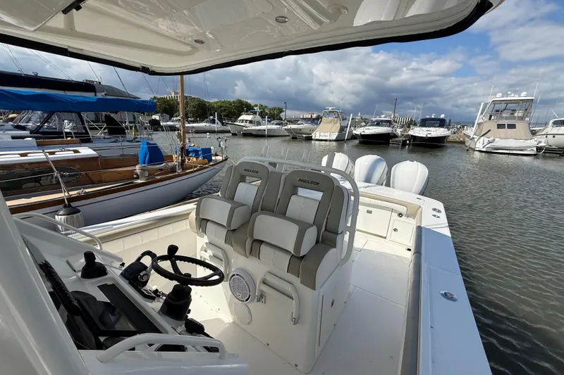 Slide: The Image of 2019 Regulator 34SS boat interior with helm and seating, docked at a marina. - 11