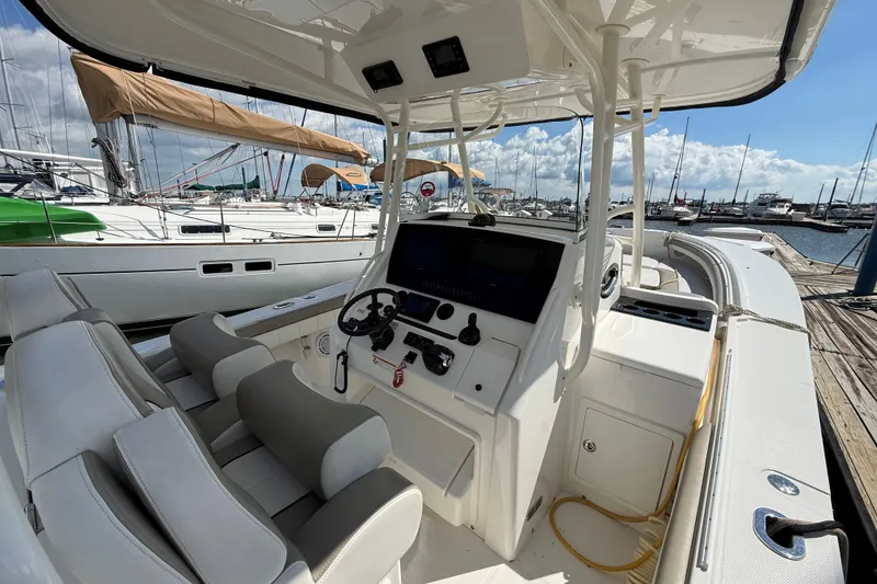 Slide: The Image of 2019 Regulator 34SS boat interior at marina, featuring helm and seating. - 15