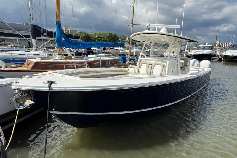The Image of 2019 Regulator 34SS boat docked in a marina with other vessels. - 0