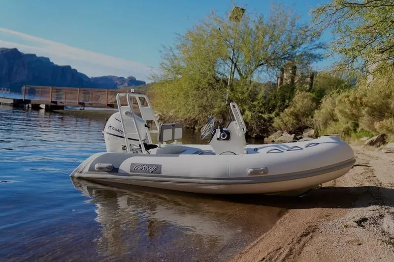 Slide: The Image of Tide Craft San Juan 11 boat, 2027 model, docked on a serene lakeside beach. - 12