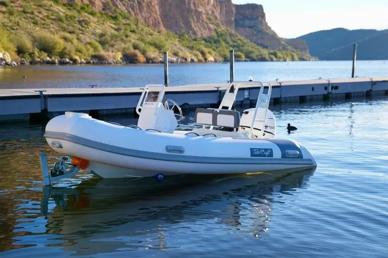 Slide: The Image of Tide Craft San Juan 11 boat docked on a serene lake, 2027 model. - 14