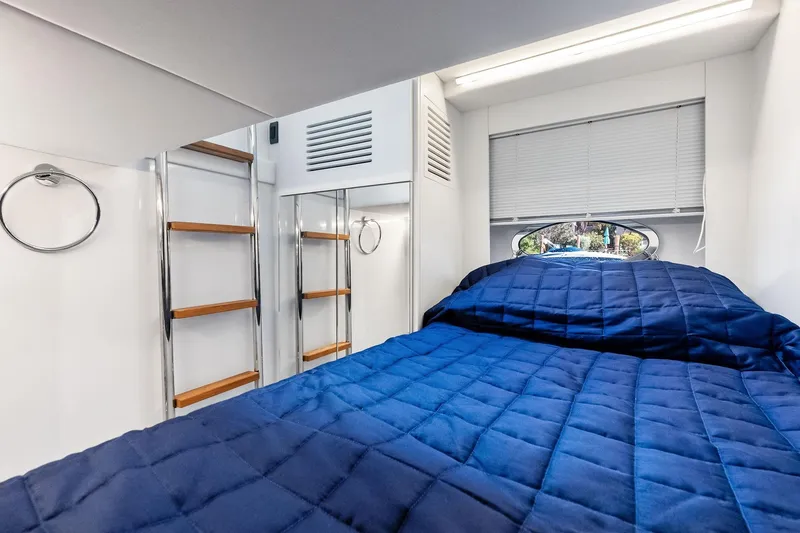 Slide: The Image of Interior cabin of 2023 Pershing 6X yacht with blue bedding and modern design. - 54
