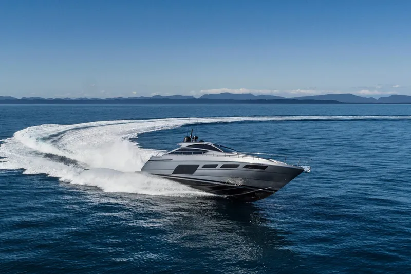Slide: The Image of 2023 Pershing 6X yacht cruising swiftly on open sea with scenic mountain backdrop. - 3